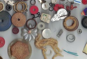 Photo description: a smattering of broken and disorganized sewing notions, metal bits, and random small parts
